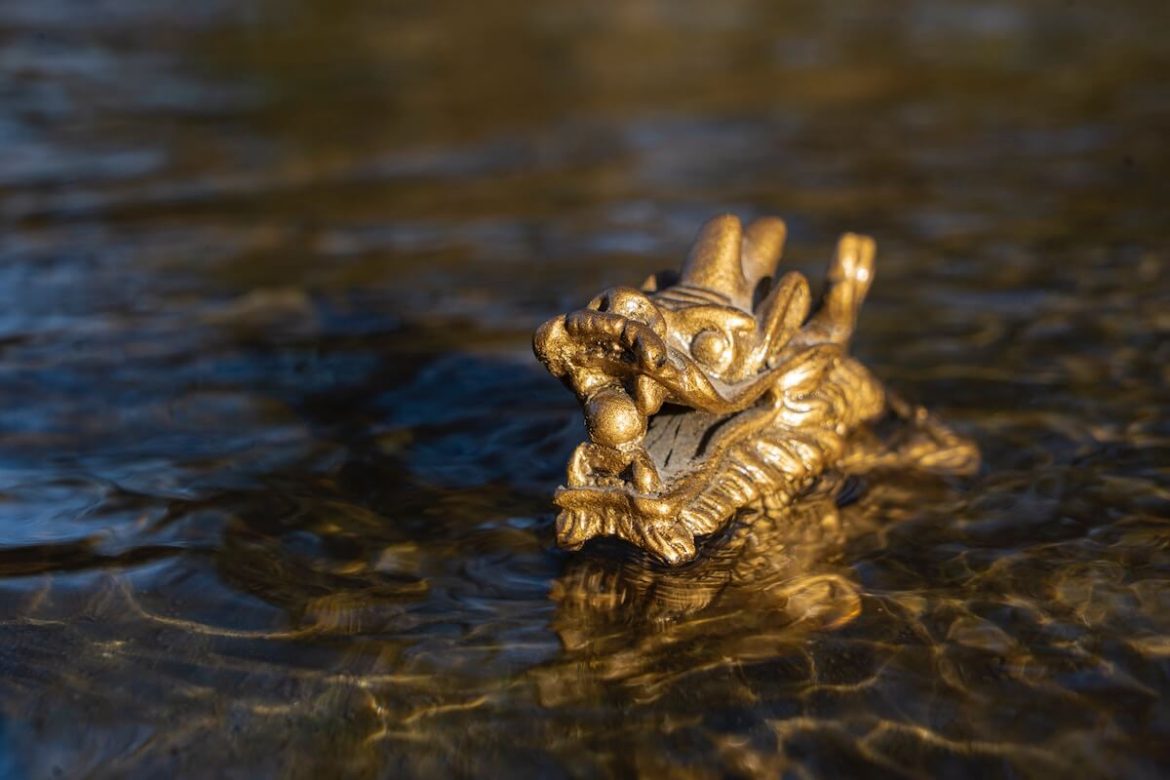 ryan-moulton-59pB_NL7Bgw-unsplash złota-figurka-chińskiego-smoka-wystająca-z-wody
